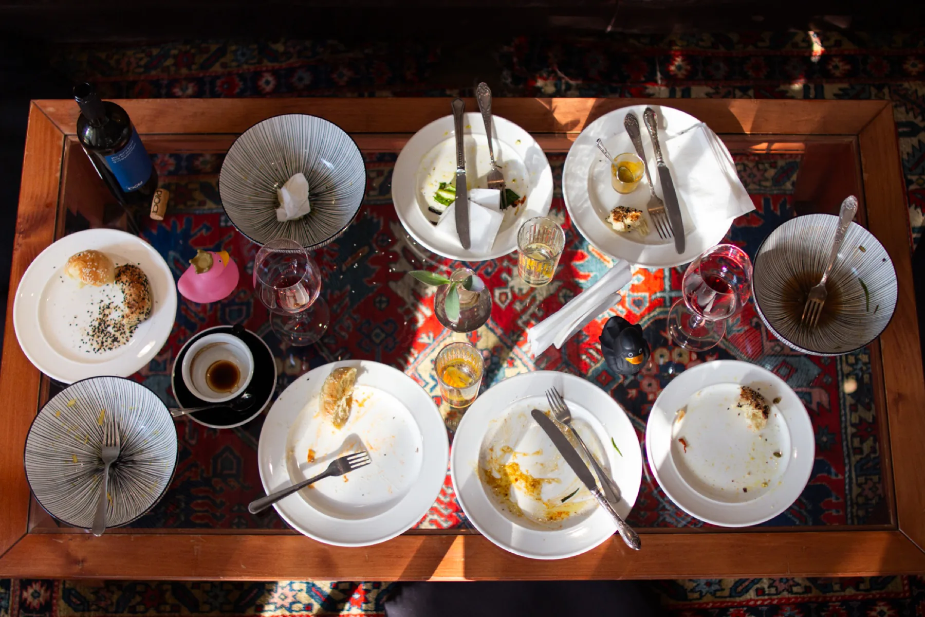 Greenpoint table after a meal, with shared plates, glasses, and colorful café details