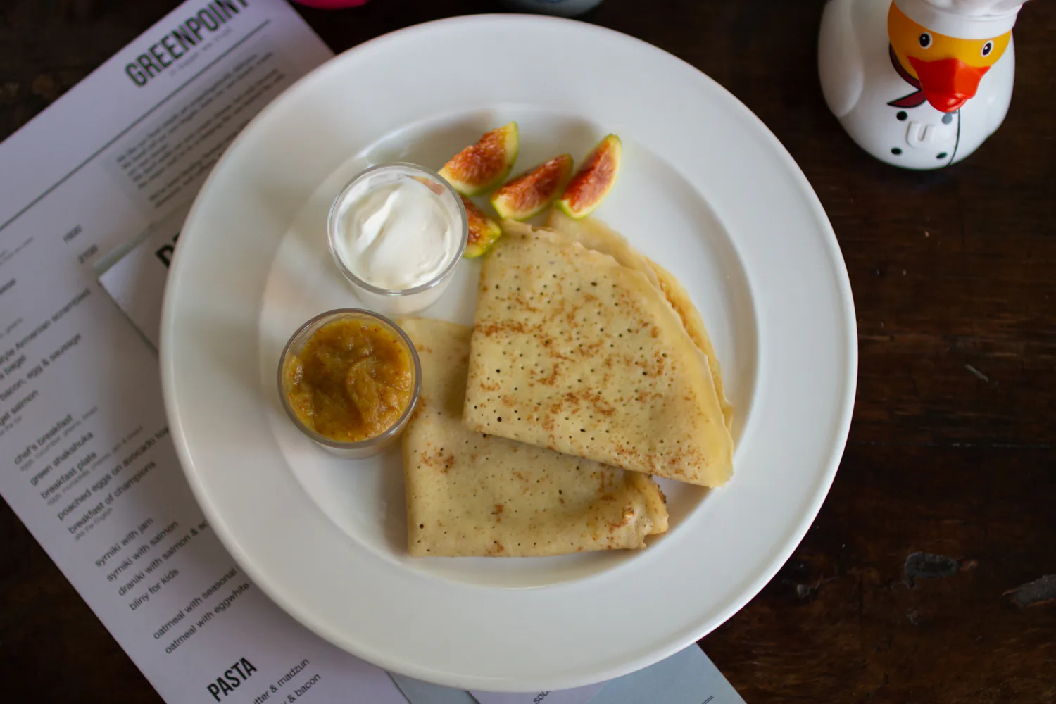 Bliny served with fruit, jam, and sour cream