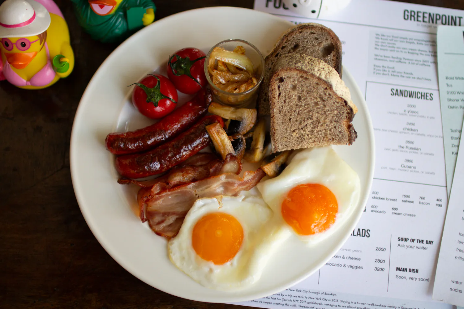 Breakfast of champions with eggs, bacon, sausages, mushrooms, tomatoes, and bread