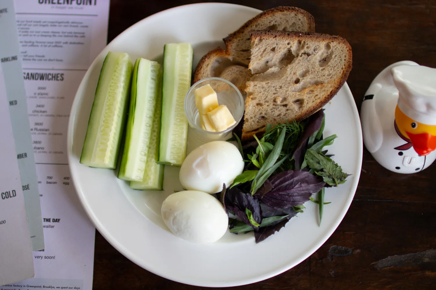 Chef's breakfast with eggs, cucumber, fresh herbs, butter, and bread