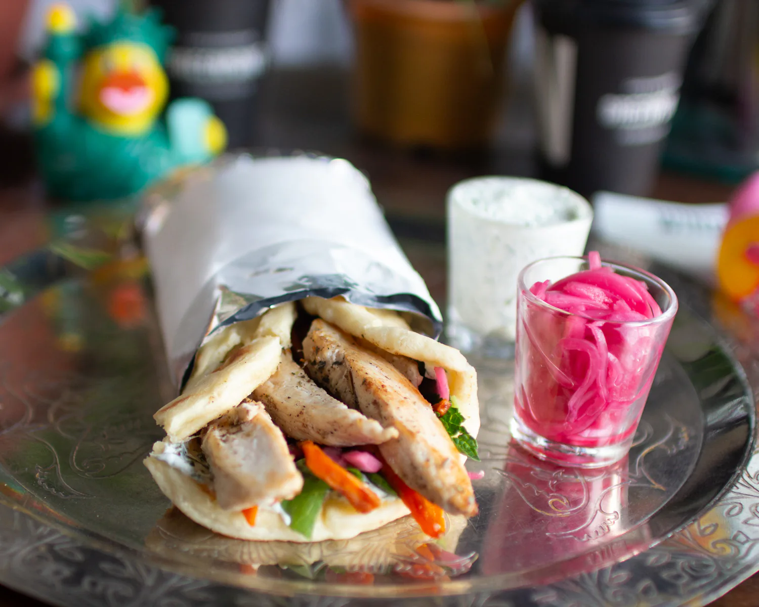 Chicken gyros in pita with tzatziki, sweet potato, and pickled onion